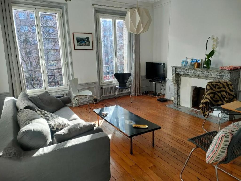 a living room with a couch and a coffee table at Lumineux,chic, appartement Haussmannien de 50 m2 in Clichy