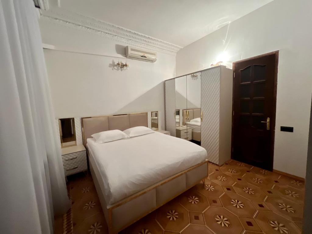 1 dormitorio con cama blanca y espejo en IT Hotel Yerevan, en Ereván