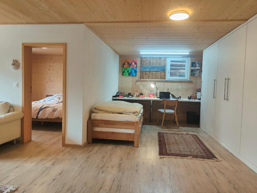 - une chambre avec un lit et un bureau dans l'établissement Casa LeYu mitten in Ruschein, à Ruschein