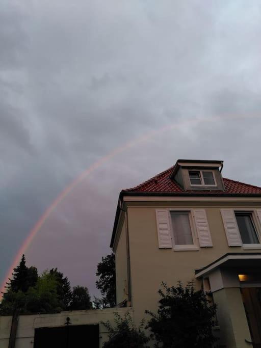 a rainbow in the sky above a house at steenkamp•studio Auntys' Chamber in Hamburg