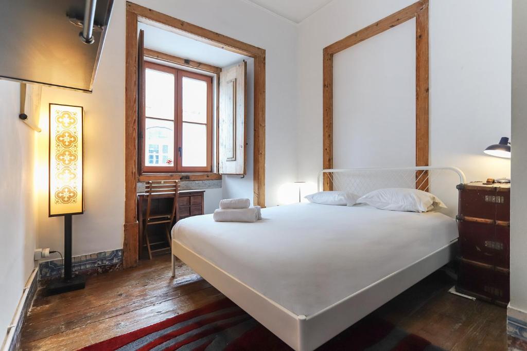 sypialnia z białym łóżkiem i oknem w obiekcie Downtown Vintage Suites by Homing w Lizbonie