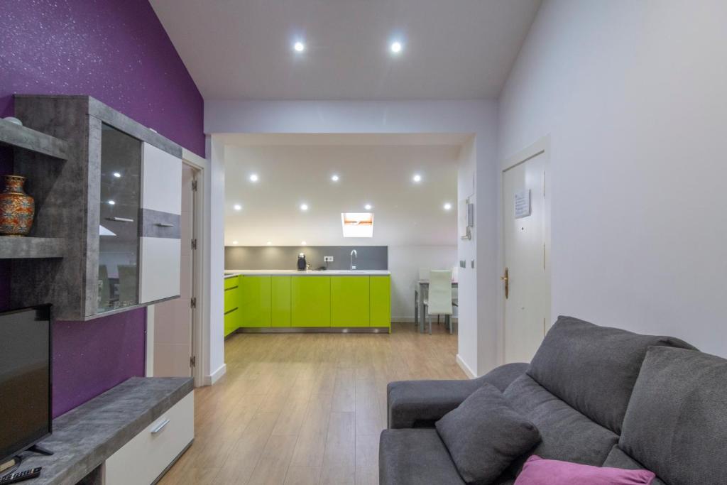a living room with a couch and a kitchen at APARTAMENTO HOLIDEA centro ciudad in Santander