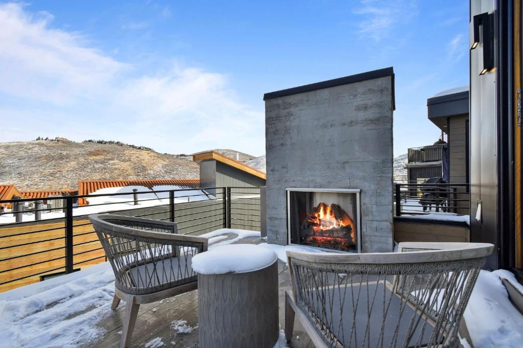 a fireplace on the deck of a house with snow at Hotel Whiskey in Park City