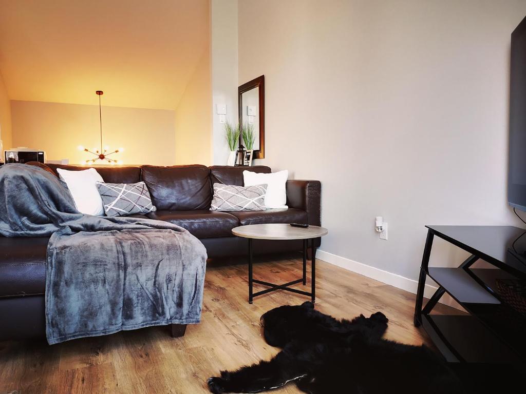 un perro negro tirado en una sala de estar con sofá en Condo sur 2 niveaux avec magnifique vue sur la montagne, en Stoneham