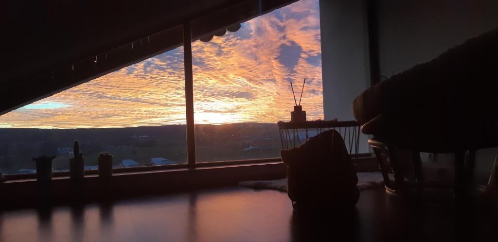um quarto com uma janela com vista para o pôr-do-sol em Pokoj s krásným výhledem v podkroví em Chrudim