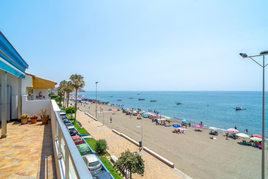 a beach with a crowd of people and the ocean at Ático en primera línea de playa con vistas al mar in Cala del Moral
