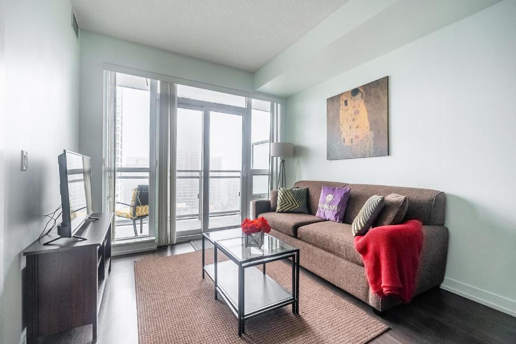 a living room with a couch and a glass table at Modern Dunfield Ave Condos by GLOBALSTAY in Toronto