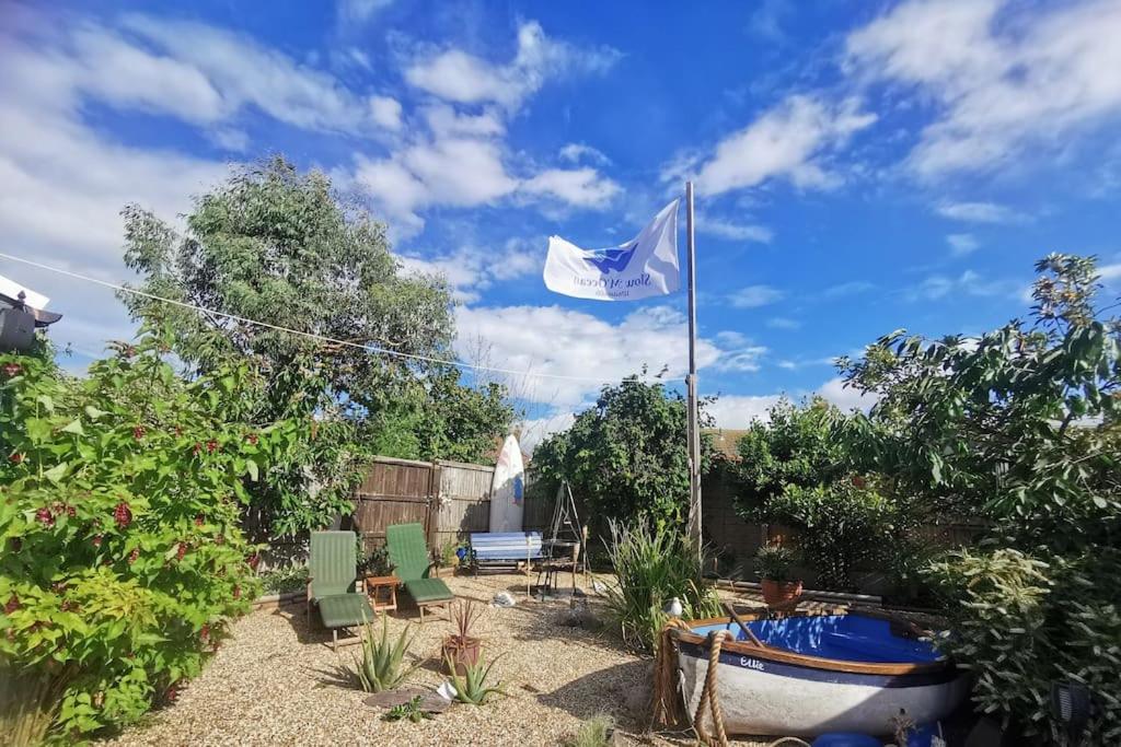 a flag flying in a yard with chairs and a boat at Sunny Family Residence with parking. Jacuzzi bath perfect for relaxing and unwinding in Kent