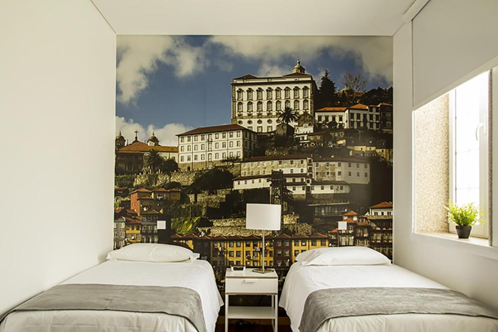 - une chambre avec 2 lits et une fresque murale représentant une ville dans l'établissement Clerigos View, à Porto
