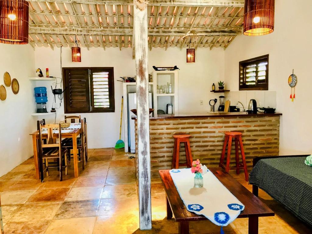 a living room with a table and a kitchen at Pousada Tangerina in Icaraí