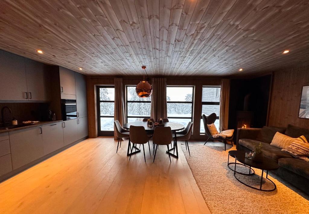 uma sala de estar com mesa e cadeiras e uma cozinha em Norebu - Norefjell em Noresund