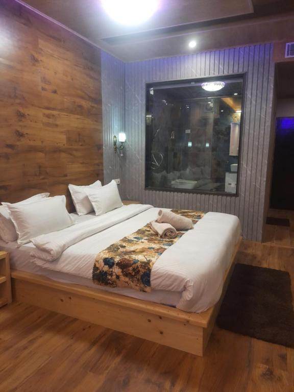 a bedroom with a large bed with white pillows at Manali mountain River Hotel & Resort in Manāli