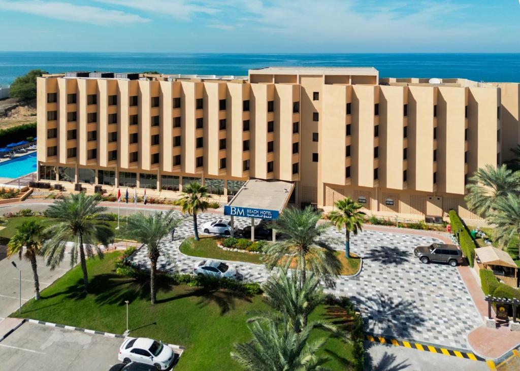 an aerial view of a hotel with palm trees and the ocean at BM Beach Hotel in Ras al Khaimah