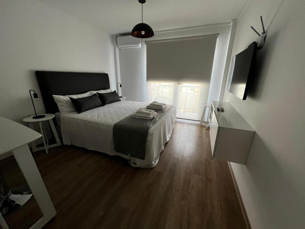 ein Schlafzimmer mit einem großen Bett und Holzboden in der Unterkunft NECOCHEA Centro MONOAMBIENTE PARA 2 PERSONAS in Necochea