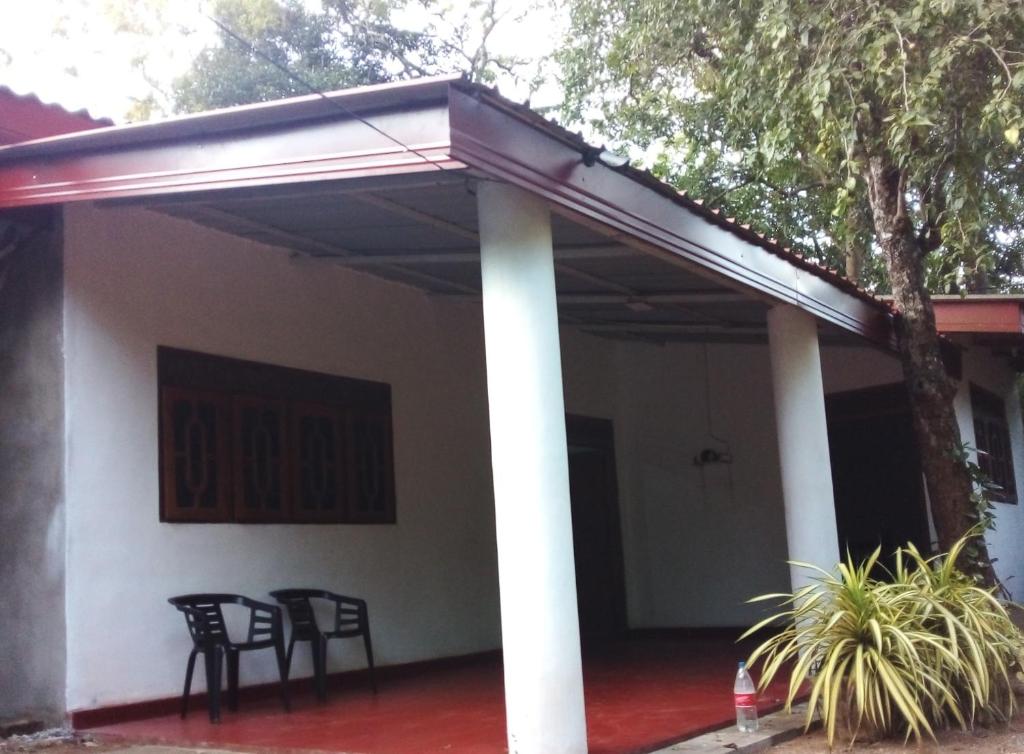 awning on the side of a house with chairs at Sanasuma Piyasa Holiday Home in Anuradhapura