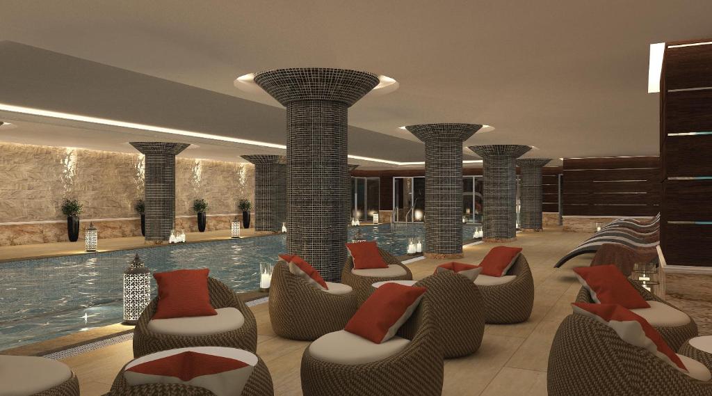 a hotel lobby with a swimming pool and chairs at Mihrako Hotel & Spa in As Sulaymānīyah