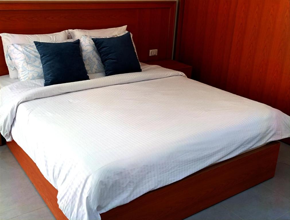 a large bed with blue pillows on top of it at Scandic Resort Apartment B 608 Hurghada in Hurghada