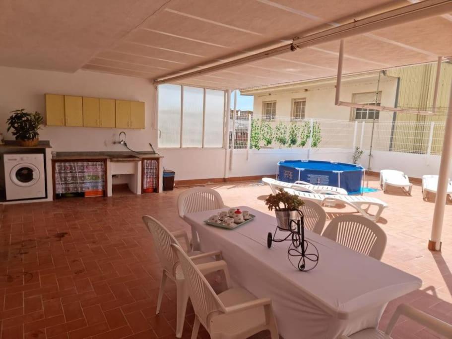 a room with a table and chairs and a pool at Casa con chimenea-4 habit.-2 baños-Gran terraza in Alcanar