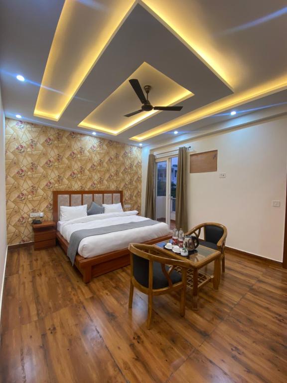 a bedroom with a large bed and a table at Tulip inn in Greater Noida