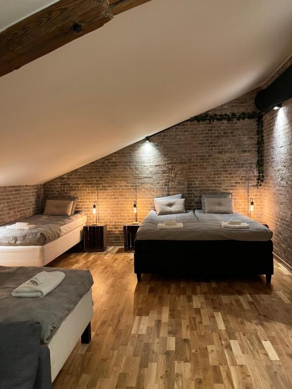 1 dormitorio con 2 camas y pared de ladrillo en Spirit Bed & Breakfast en Ekeby