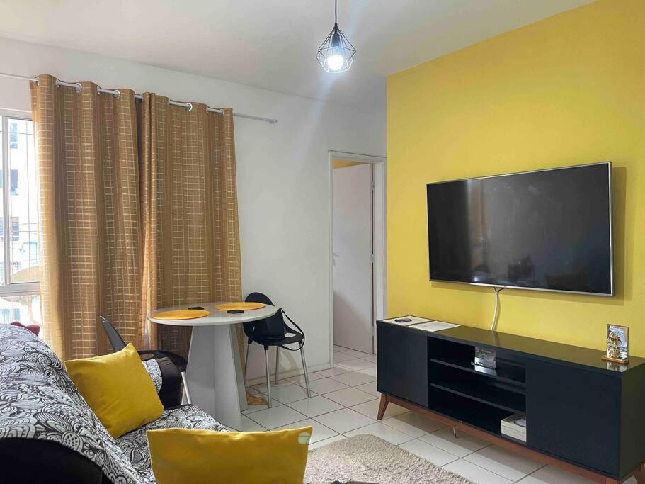 uma sala de estar com uma grande televisão de ecrã plano numa parede amarela em Apartamento Salvador em Salvador