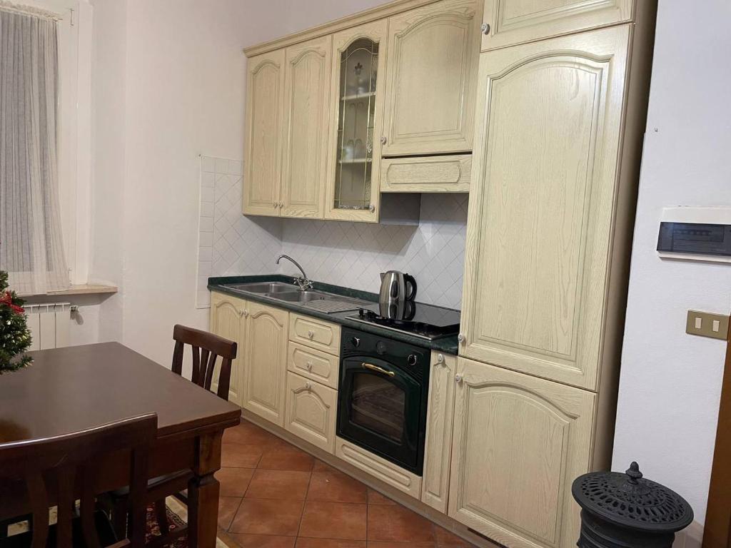 a kitchen with white cabinets and a black stove top oven at La Casina di Maya in Livorno