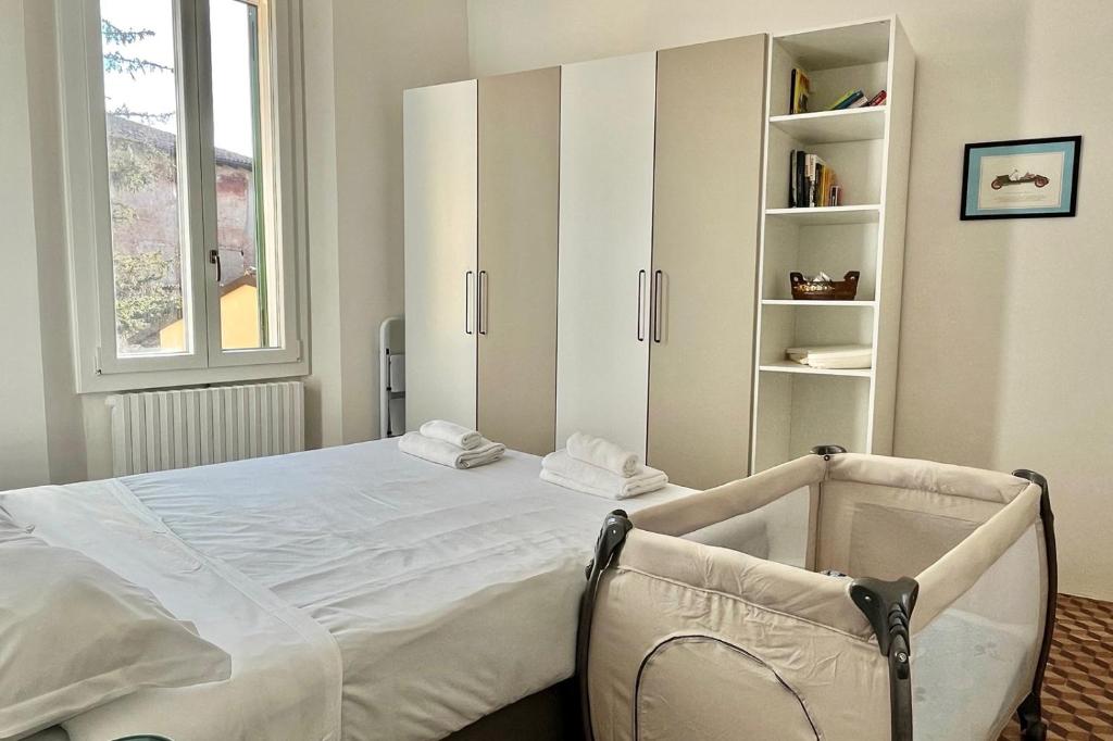 een slaapkamer met een groot wit bed en een boekenplank bij Appartamento Mascarella 19 in Bologna