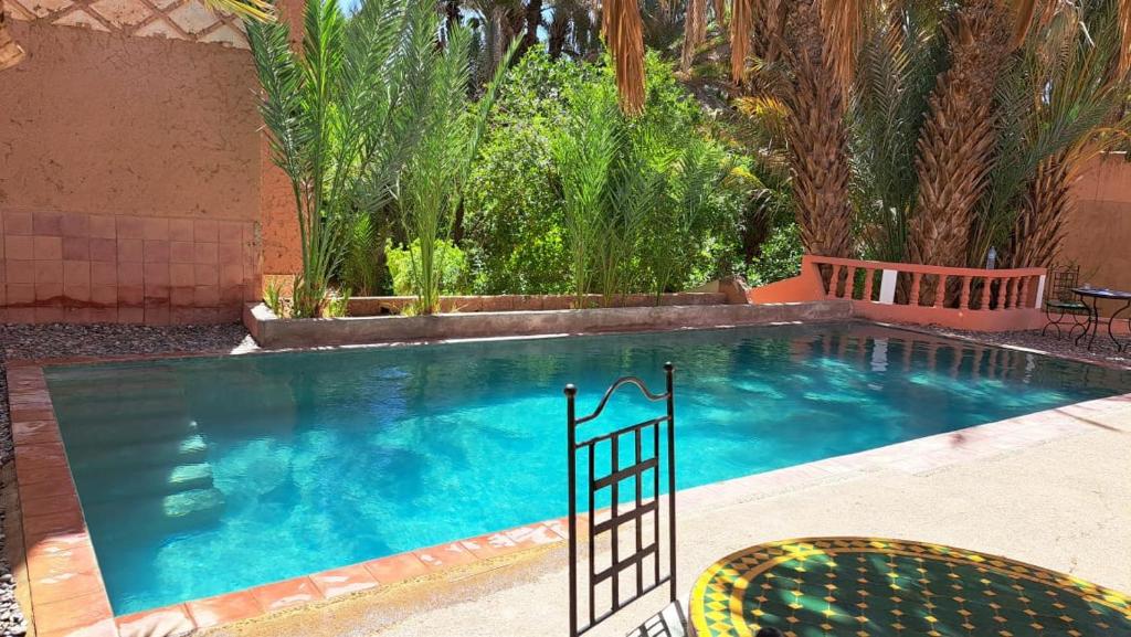 uma grande piscina com duas cadeiras em Au jardin de Tamnougalt em Agdz