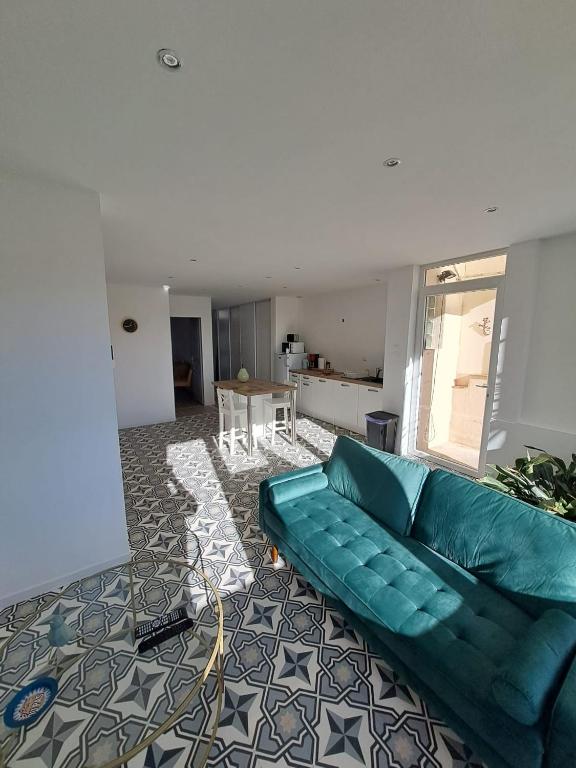 un salon avec un canapé vert et une table dans l'établissement La Petite Maison des Boettes, à Carpentras