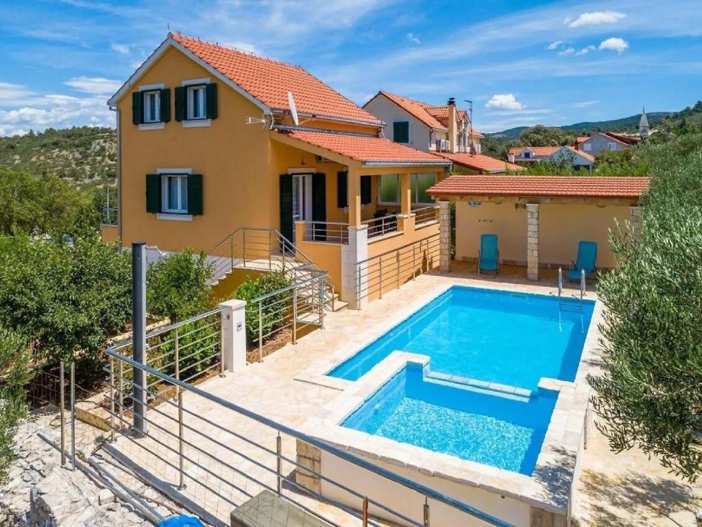 a villa with a swimming pool in front of a house at Villa Jelena in Dračevica