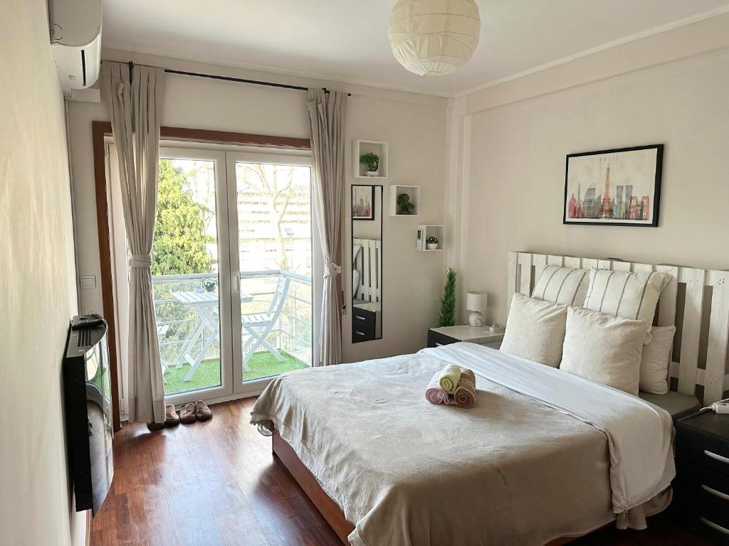 Un dormitorio con una cama con un osito de peluche. en Private Bedroom with Balcony & Private Bathroom in Modern Shared Apartment - King & Queen size bed, en Vila Nova de Gaia