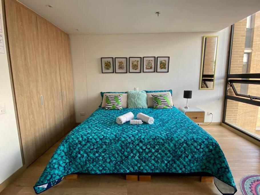 a bedroom with a large bed with two towels on it at Apartaestudio Bogotá Colombia in Bogotá