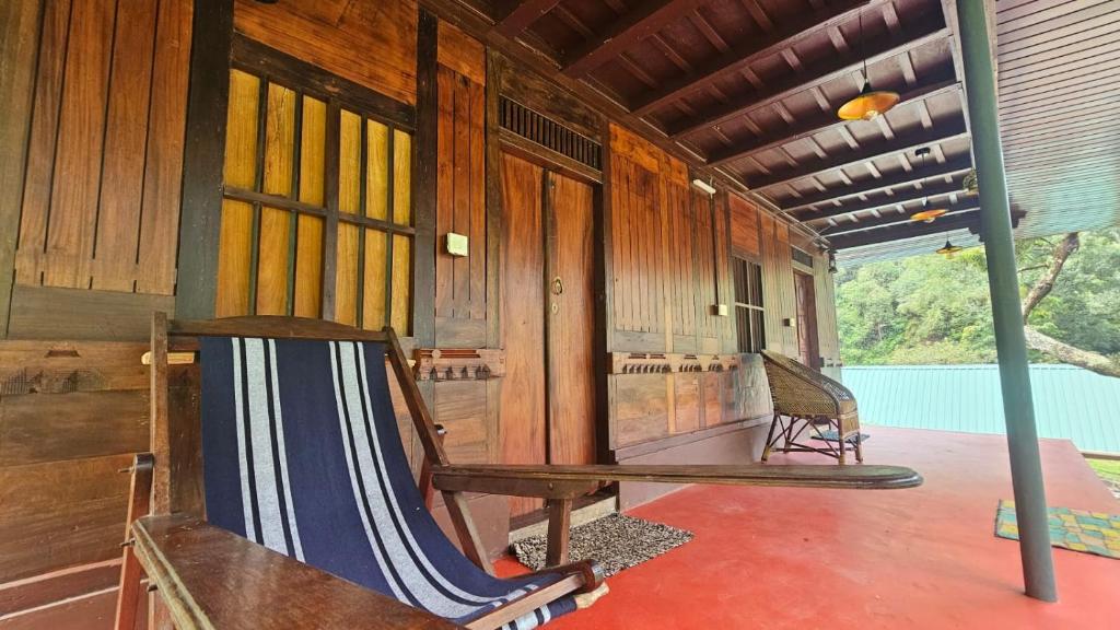 a porch of a house with a hammock in it at Vattavada Jungle Resort in Munnar