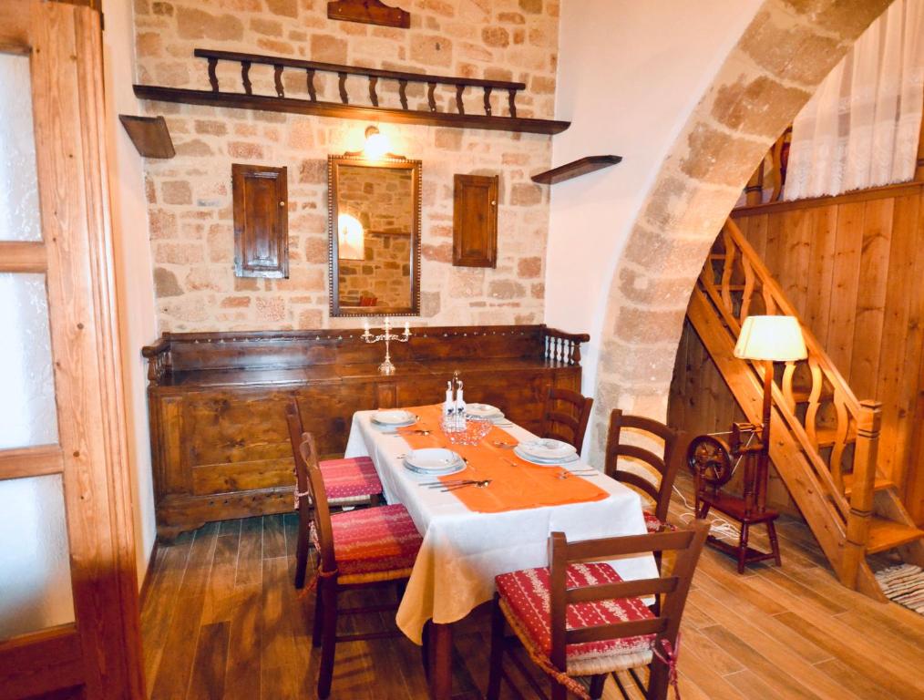 a dining room with a table and a stone wall at Villa Patitiri Traditional House in Archangelos