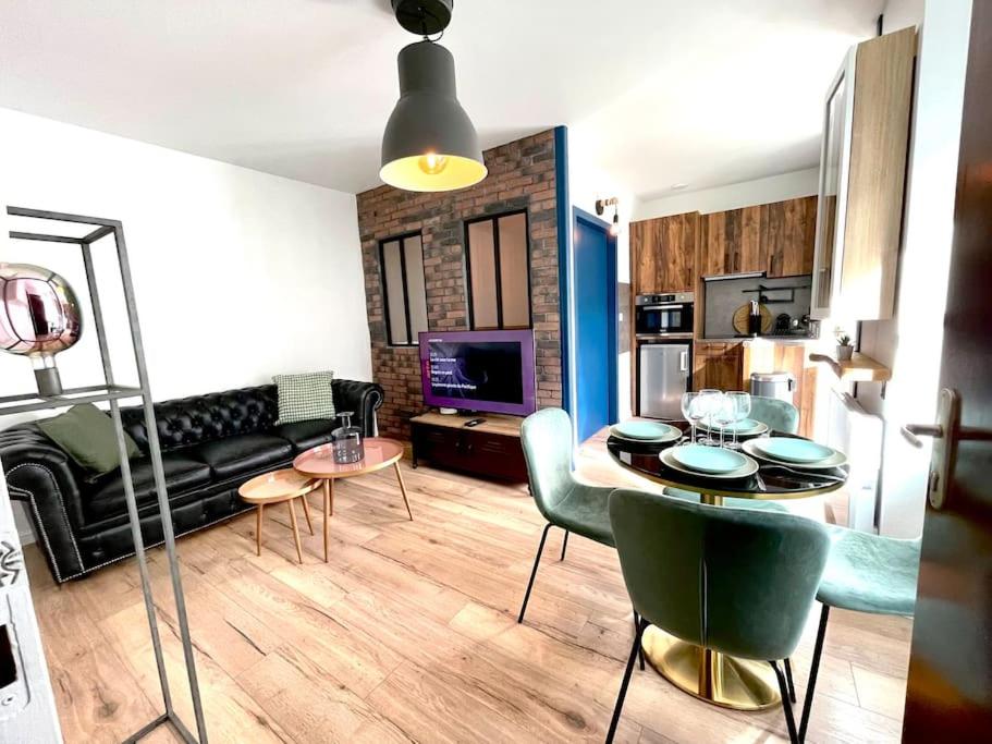 salon ze stołem i krzesłami oraz kuchnię w obiekcie Magnifique Appartement Hypercentre - Le Charly w mieście Pau