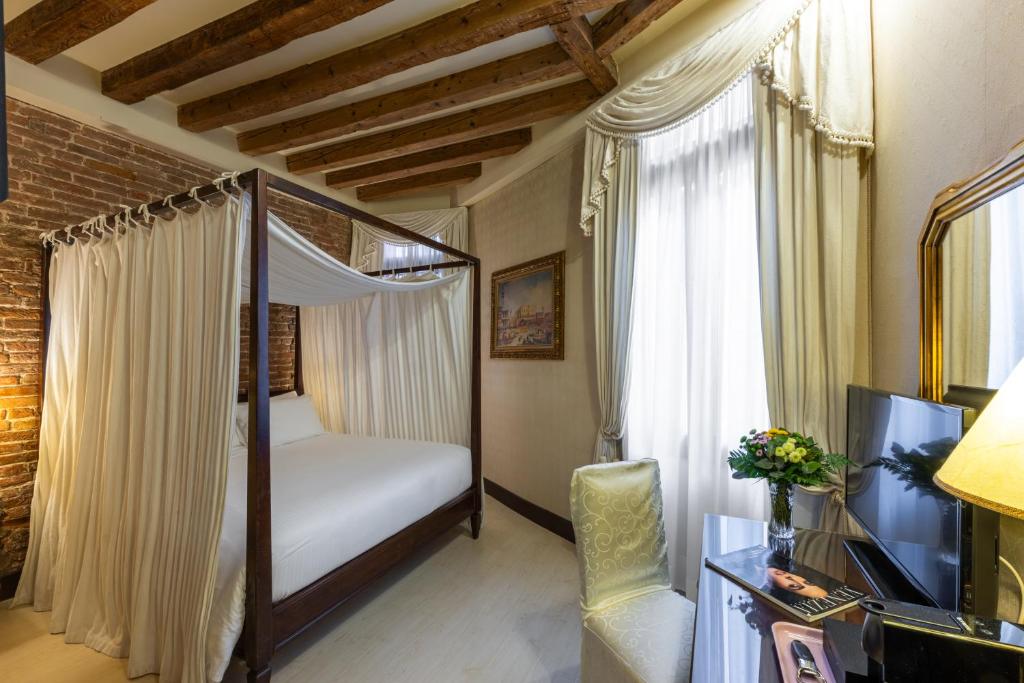 a bedroom with a canopy bed and a television at Ca' Del Nobile in Venice