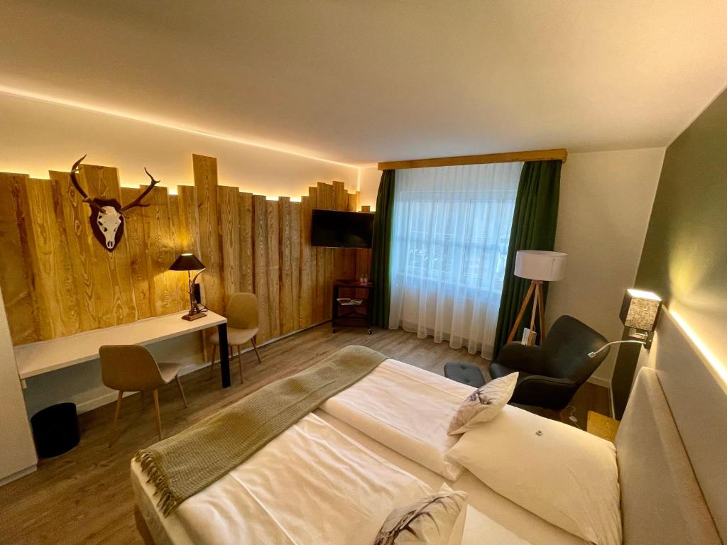 a hotel room with a bed and a desk and a room at Hotel &amp; Restaurant Bergfried in Saalfeld