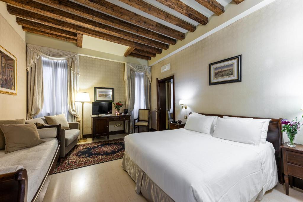 a bedroom with a large white bed and a couch at Ca' Del Nobile in Venice