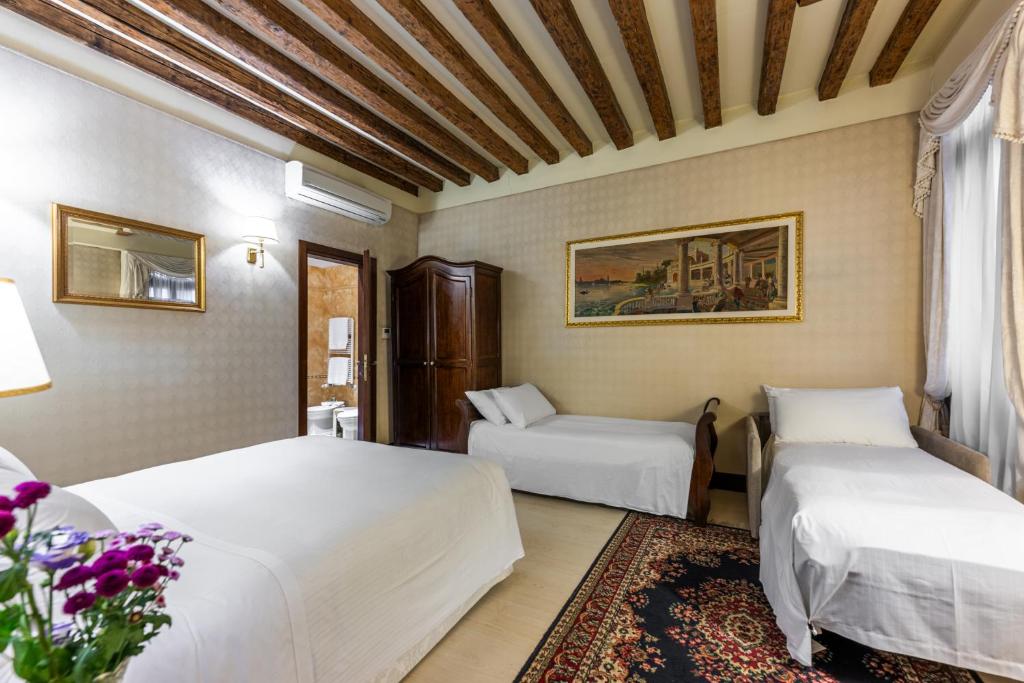a hotel room with two beds and a couch at Ca' Del Nobile in Venice