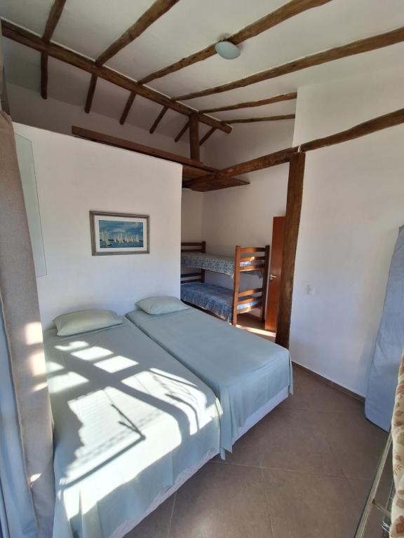 - une chambre avec un lit et un plafond en bois dans l'établissement Alma Surf House, à Boicucanga