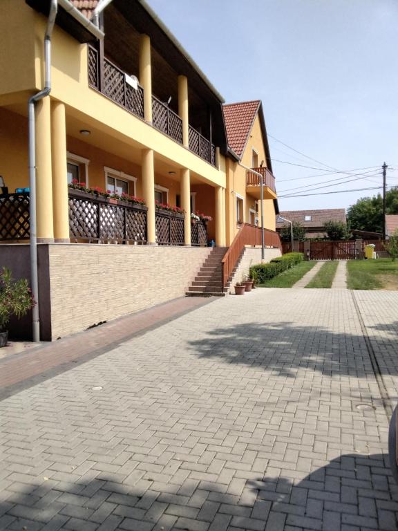 a building with a brick driveway in front of it at Gulyás Vendégház in Tiszafüred