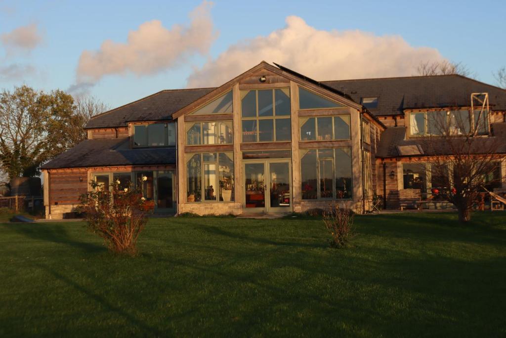 a large house with large windows on a lawn at Mapperton Barn House B&B Nr Stourhead & Longleat in Mere