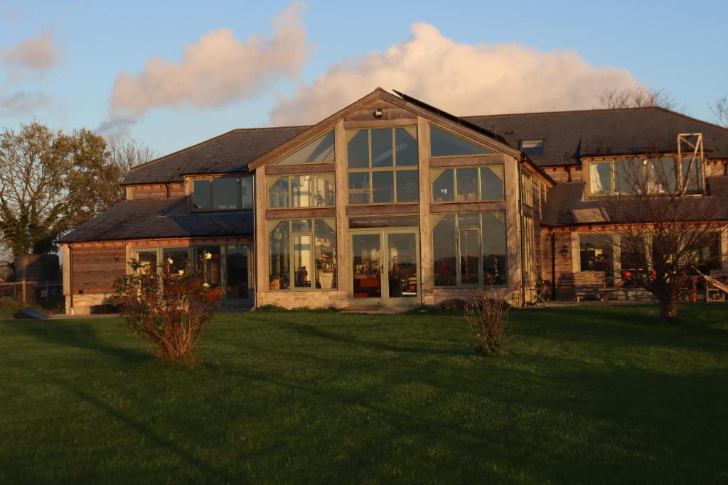 a large house with large windows on a lawn at Mapperton Barn House B&B Nr Stourhead & Longleat in Warminster