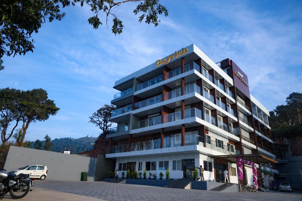 un edificio de hotel con un cartel en él en OXYRICH, en Madikeri