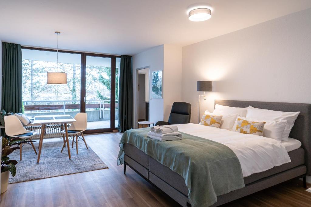 - une chambre avec un lit, une table et des chaises dans l'établissement MESSE und UNI-Nähe: Moderne Wohnung mit Parkplatz und Küche, à Augsbourg