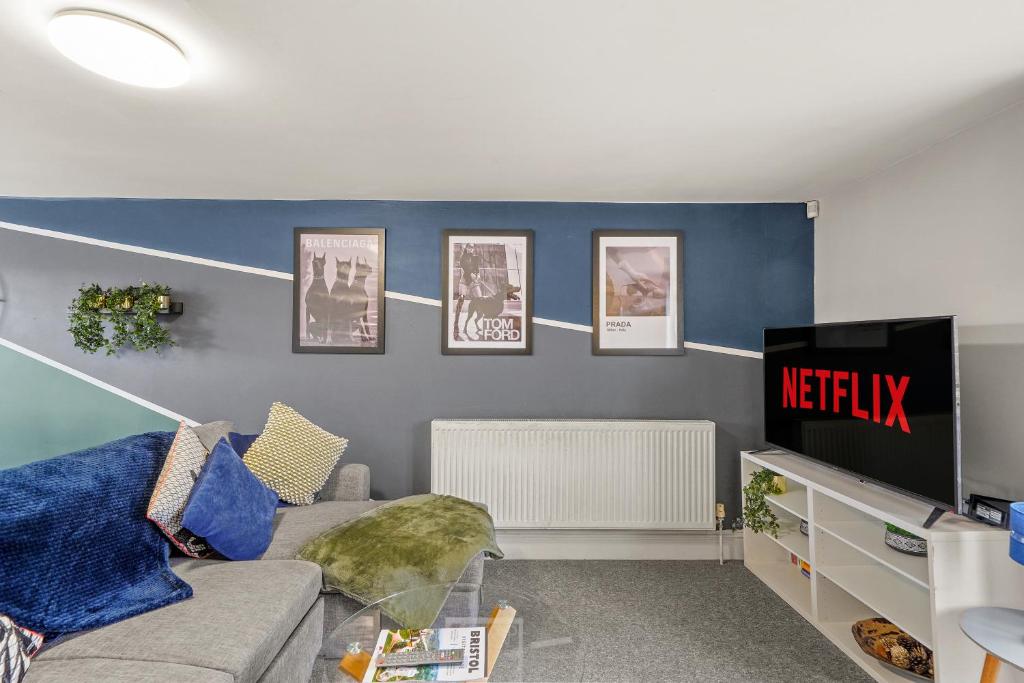 uma sala de estar com um sofá e uma televisão em Beautiful Duplex with Private Rooftop - Sleeps 6 em Bristol