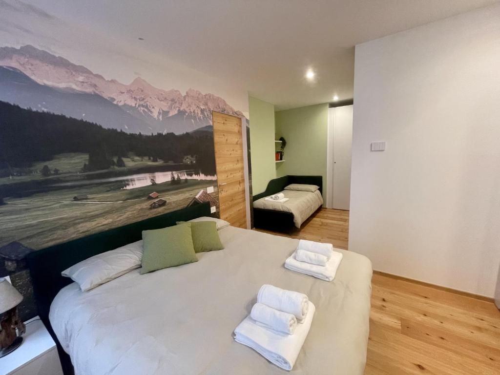 a bedroom with a large bed with towels on it at Appartamento Fondo Valle a 1 minuto dalle piste in Madesimo