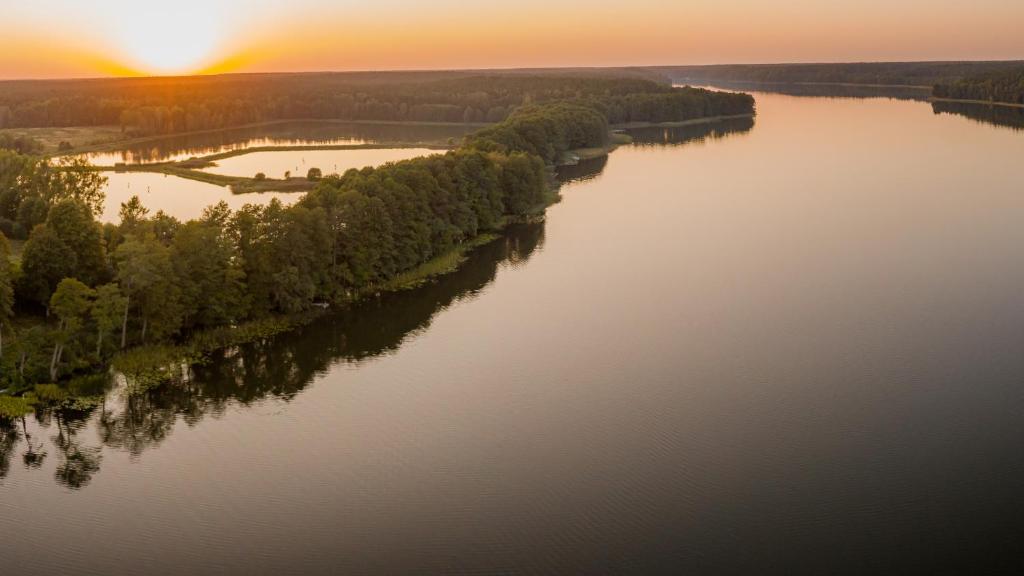 una vista aerea di un fiume al tramonto di Natural Hotel w Rezerwacie z Plażą Na Wyspie a Ostróda