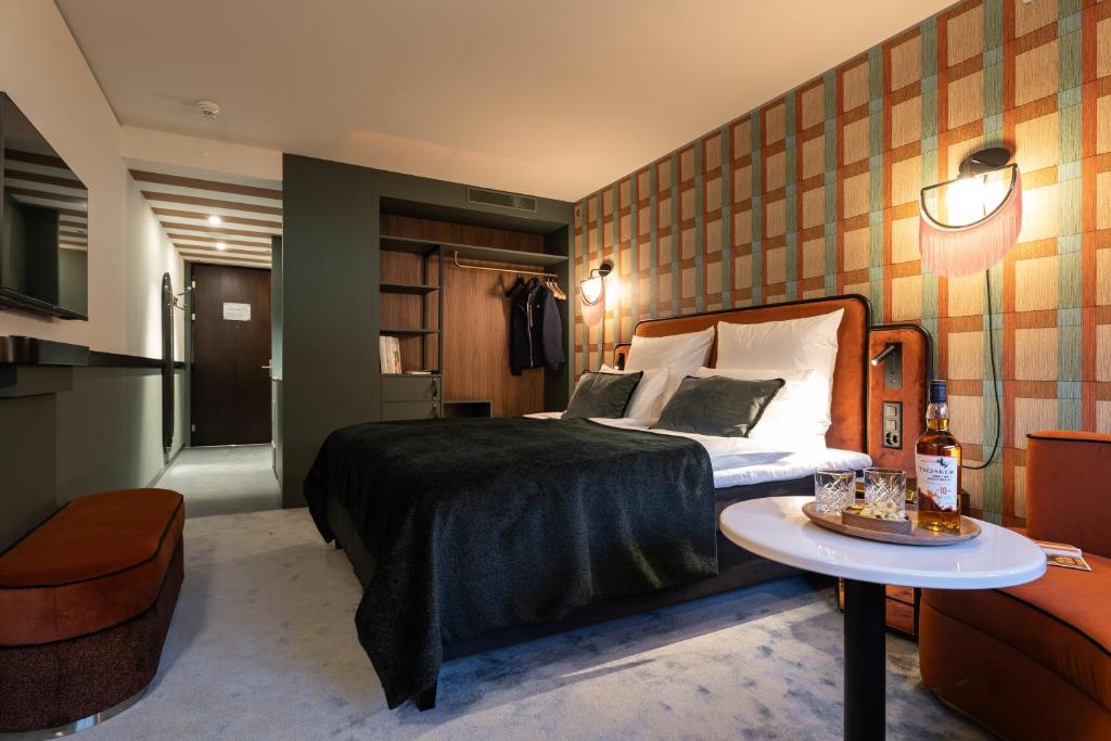 The Home Hotel Zürich - a member of DESIGN HOTELS في زيورخ: غرفة في الفندق سرير وطاولة عليها كيكة