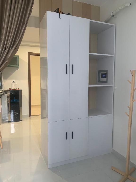 een grote witte kast in een woonkamer bij The Emerald Golf View apartment in Thuan An